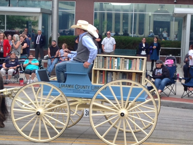 Horse drawn wagon in a parade advertising the Laramie County Library