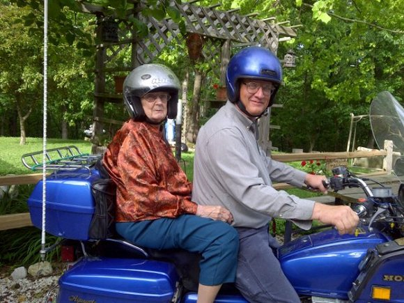 Deacon Mark Dobelmann and Irene Doberlmann sitting on a motorcycle