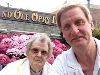Deacon Vernon Dobelmann and Irene Dobelmann standing in front of the "Grand Ole Opry House" sign in Nashville, Tennessee